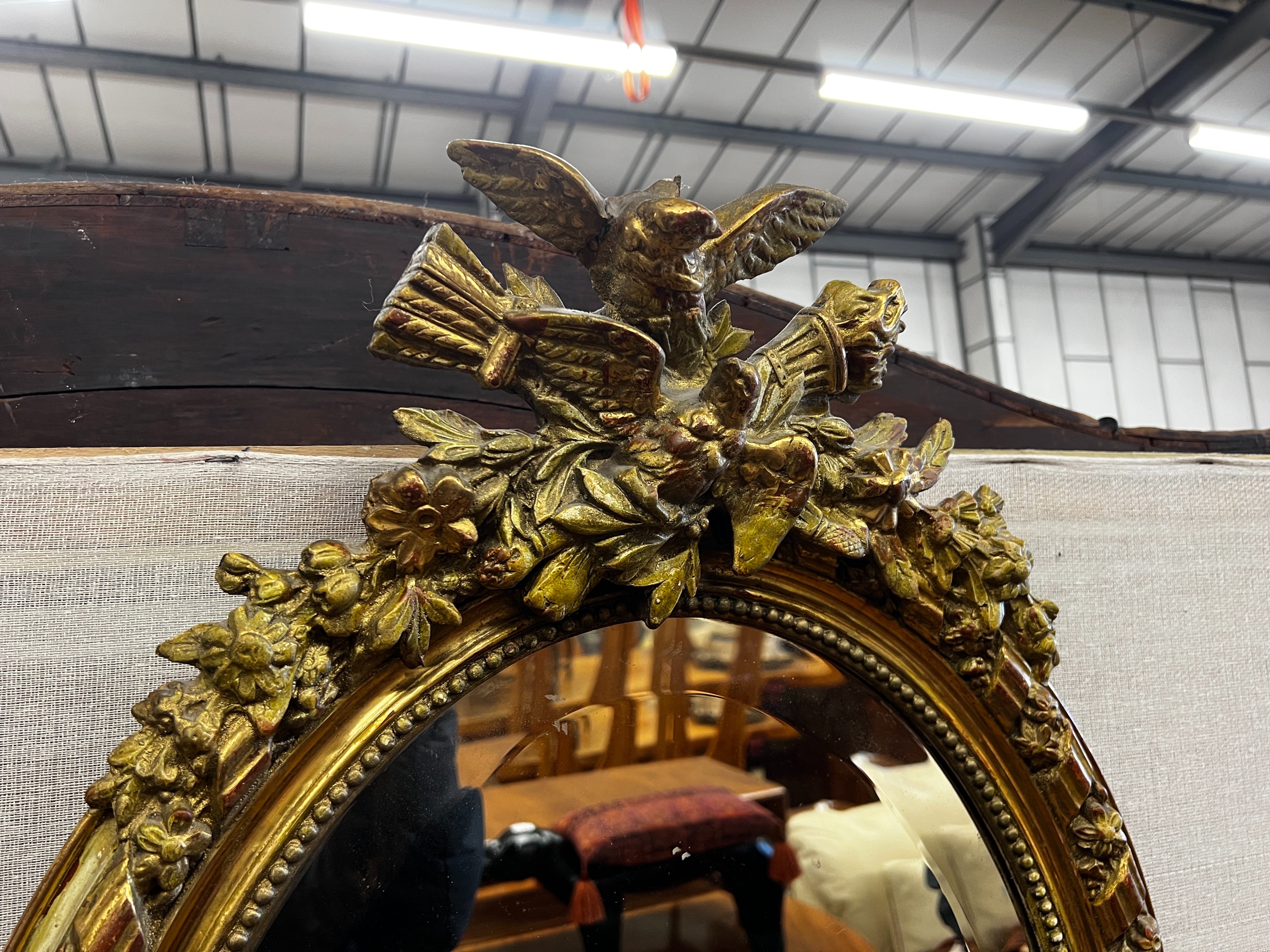 A 19th century French giltwood and composition oval wall mirror with pierced scrolling pediment, width 54cm, height 82cm